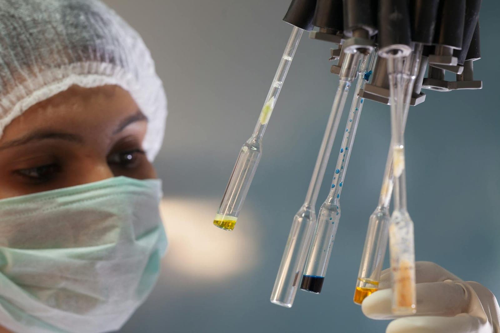 Scientist handling test tubes in a clinical laboratory setting.