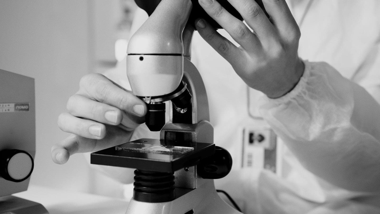 Researcher using a microscope in a laboratory.